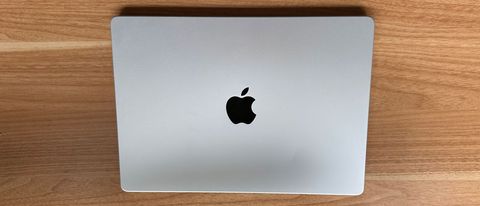 A MacBook Pro 14-inch (M2, 2023) closed on a wooden desk