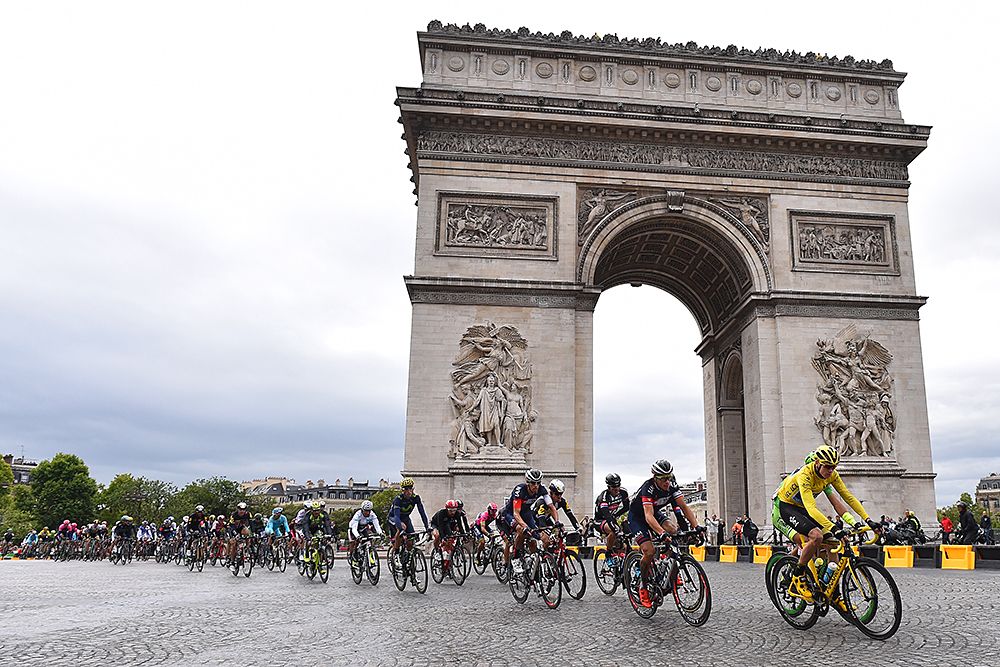 The field races around the Arc de Triomphe