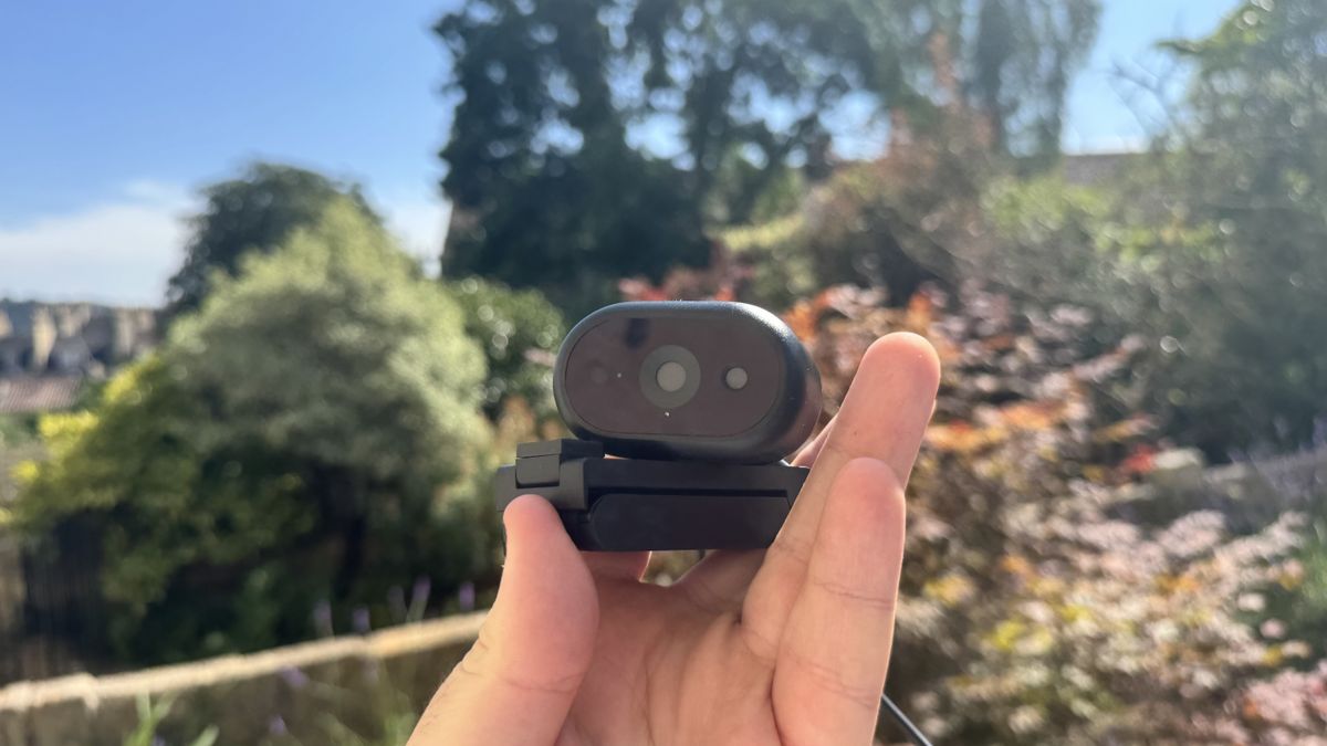 Dell Pro 5 webcam on its stand, in a hand, outside