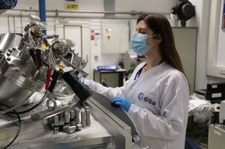 In this photo, a scientist at the European Space Agency's Materials and Electrical Components Laboratory at the ESTEC technical center in the Netherlands works on essential mission work. Most ESA employees continue to work from home due to concerns regarding the continuing COVID-19 pandemic, but certain activities are still happening on-site. This lab is supporting a variety of work including the development of new radiation-resistant coatings, which are tested by exposing them to ultraviolet and vacuum-ultraviolet light.