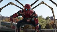 Spider-Man crouching on a car during the Marvel movie Spider-Man: No Way Home.