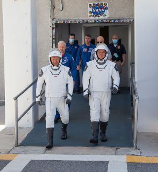 SpaceX’s Demo-2 crew members Bob Behnken (at right) and Doug Hurley walk out of the Neil A. Armstrong Operations and Checkout Building at NASA's Kennedy Space Center in Florida during a dress rehearsal for their launch, May 23, 2020.