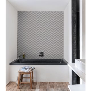 grey chevron effect wallpaper behind white bath