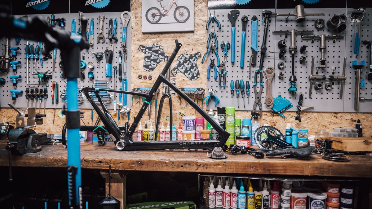 A Chapter2 frameset sits on a mechanic&#039;s workbench in front of a wall of tools