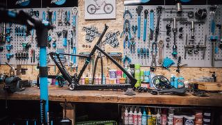 A Chapter2 frameset sits on a mechanic's workbench in front of a wall of tools