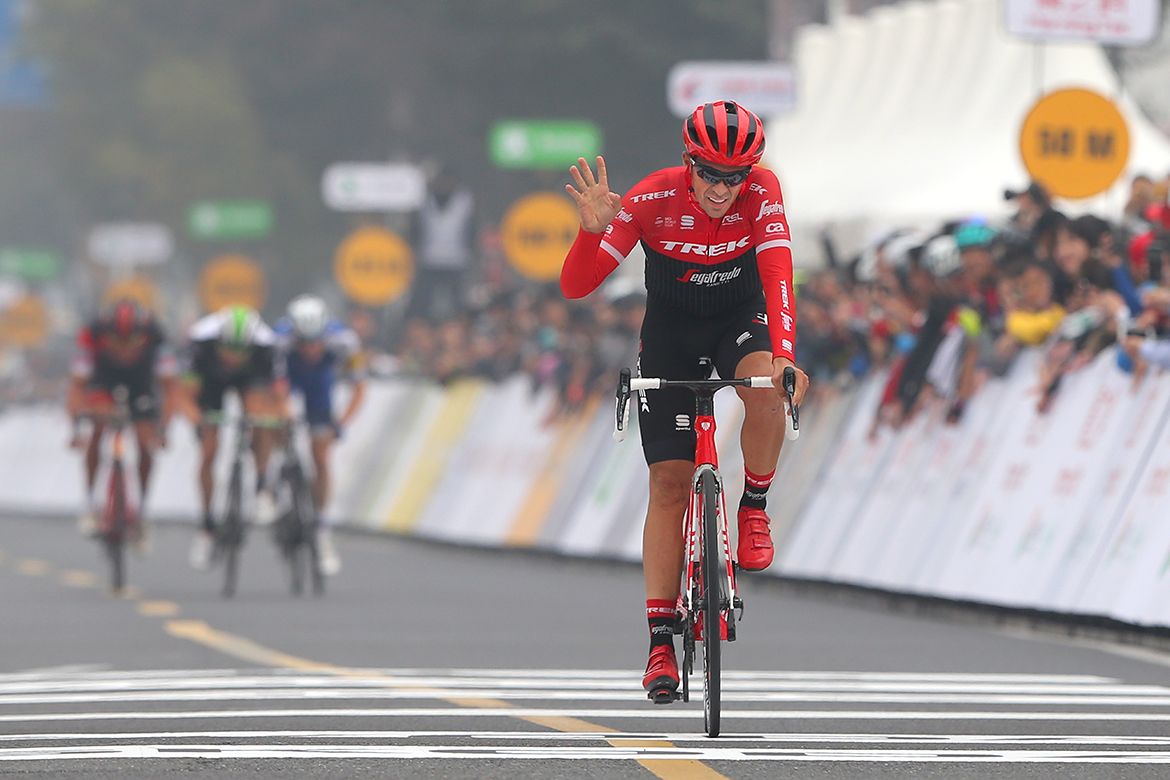 Alberto Contador waves as he crosses the line