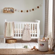 Nursery with white cot bed, knitted blanket and toy basket