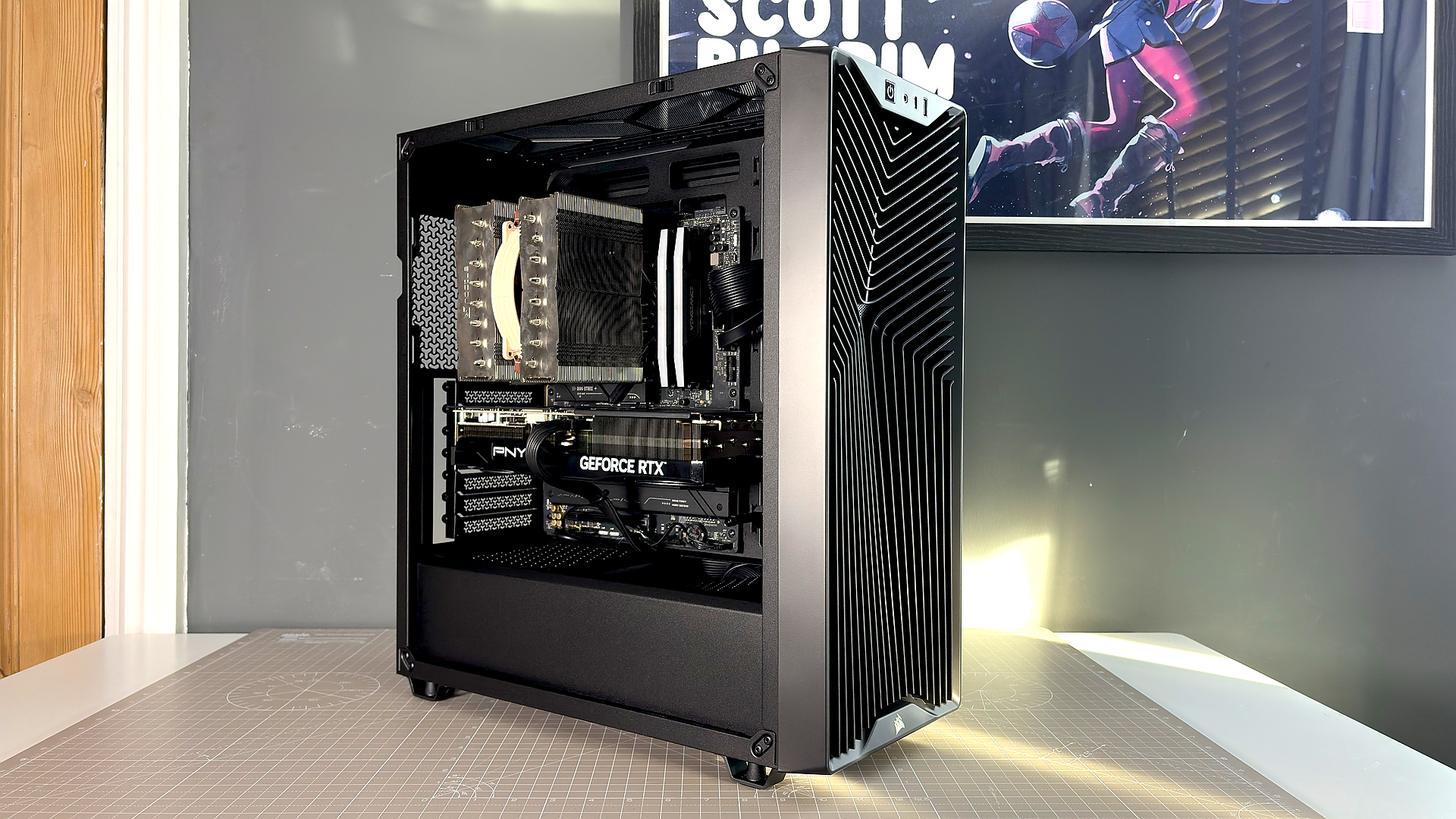 A Corsair PC case, the 3200D, on a desk with various panels removed and ready for a PC build.