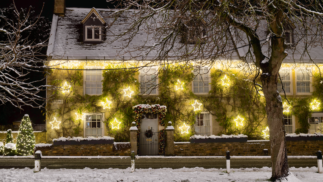  Christmas light decorations on the front of a house in the snow at night