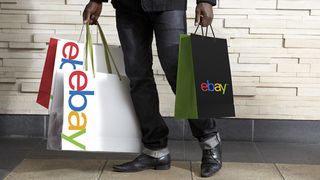 Person carrying shopping bags labelled eBay