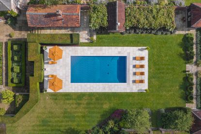 An overhead shot of a house's well-manicured backyard with a pool.