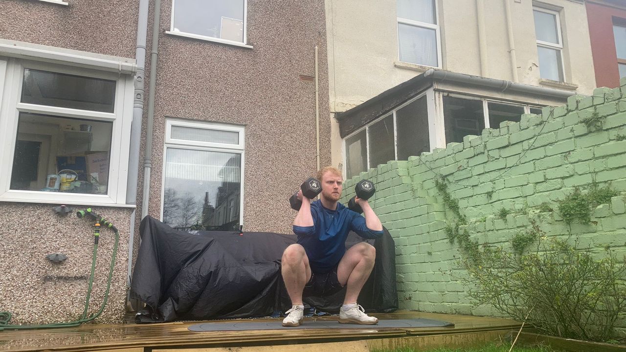 Fit&amp;Well fitness writer Harry Bullmore demonstrating a squat to overhead press