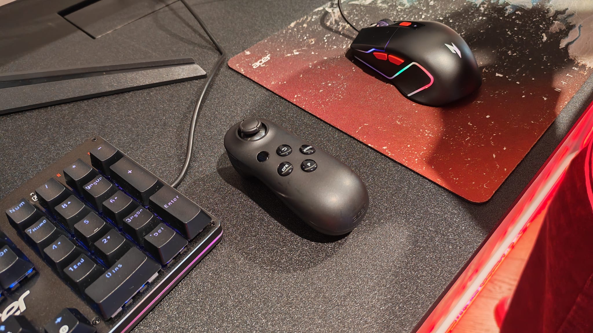 An Acer Smart Dial on a desk next to a mouse and keyboard