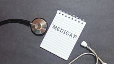 Professional medical concept with stethoscope and Medigap notepad on dark background