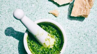 a white mortar filled with pesto