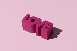 Word "love" in 3d block on pink background