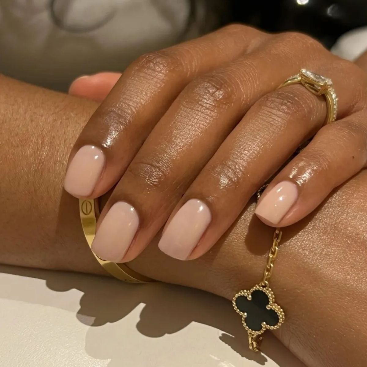 A close-up shot of a neutral, milky manicure