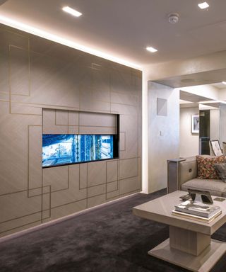 Luxurious media room with TV hidden into panel in the wall within a neutral interior scheme