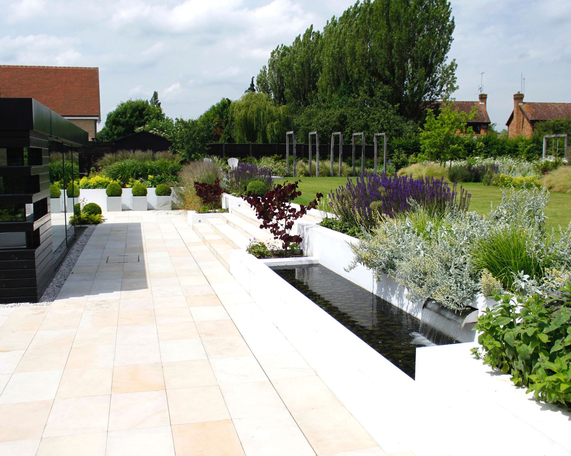 Designing a patio with a water feature in a sleek, modern garden scheme.