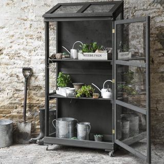 black cupboard with plant pots and shovel