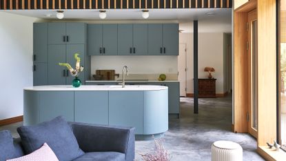 Kitchen with blue units and concrete floor
