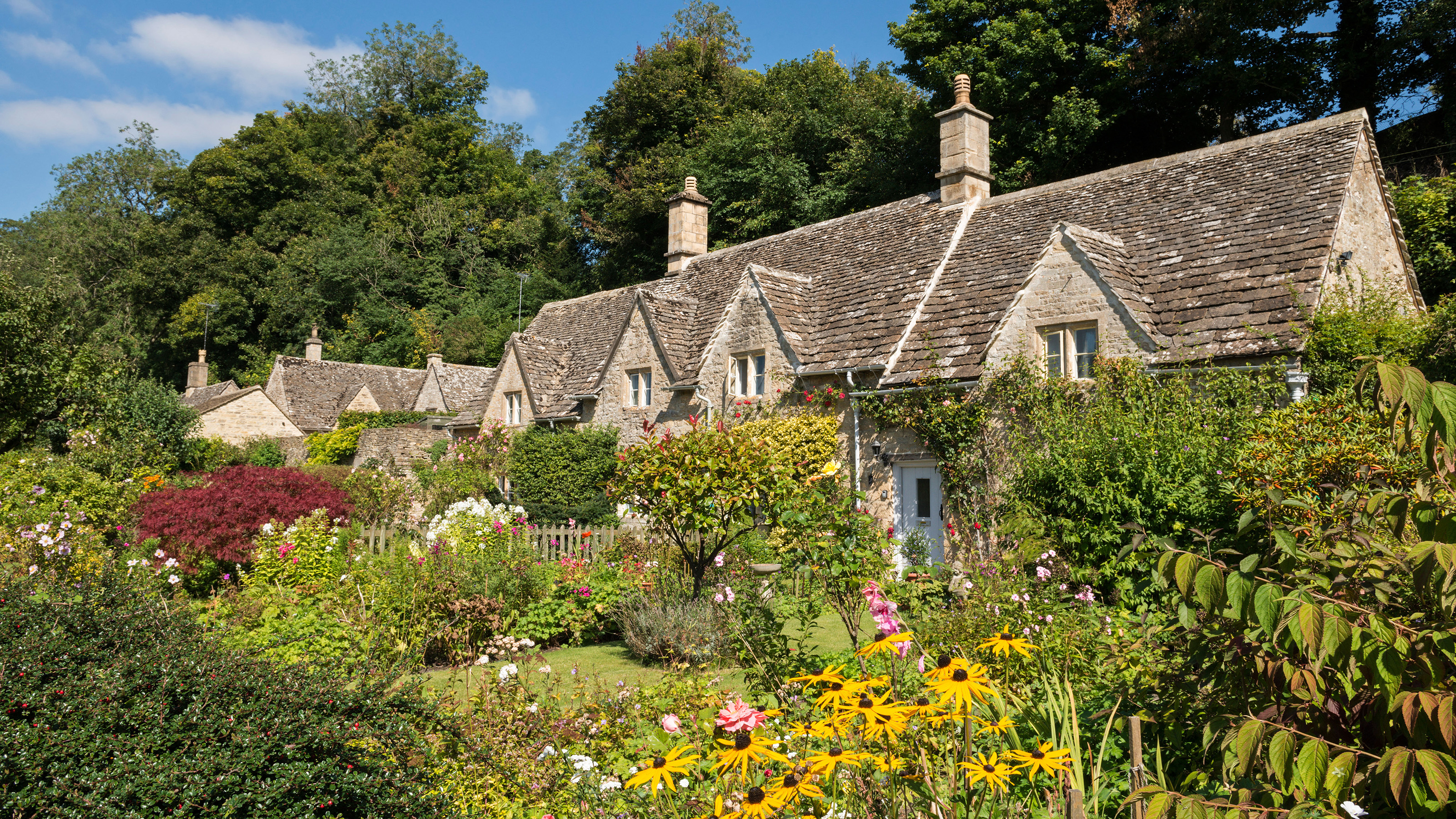Pretty country cottages and gardens in the picturesque Cotswolds village of Bibury