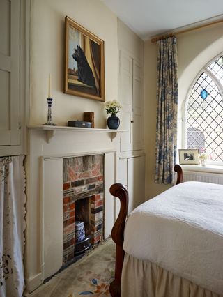 bedroom with stained glass window wooden bed and decorative fireplace
