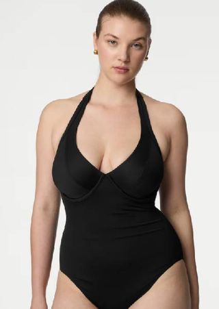 A model wearing a black halterneck swimsuit from M&S. 