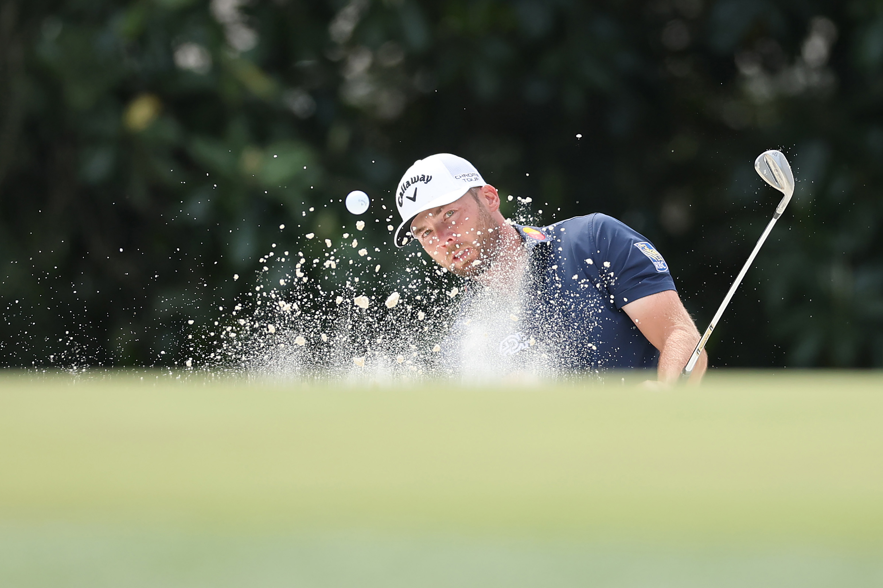Sam Burns hits out of a greenside bunker on the fifth hole during a practice round prior to the 2026 Masters Tournament at Augusta National Golf Club