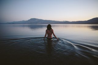 Cold water therapy: A woman swimming in a lake