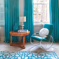 living room with wooden flooring and blue armchair