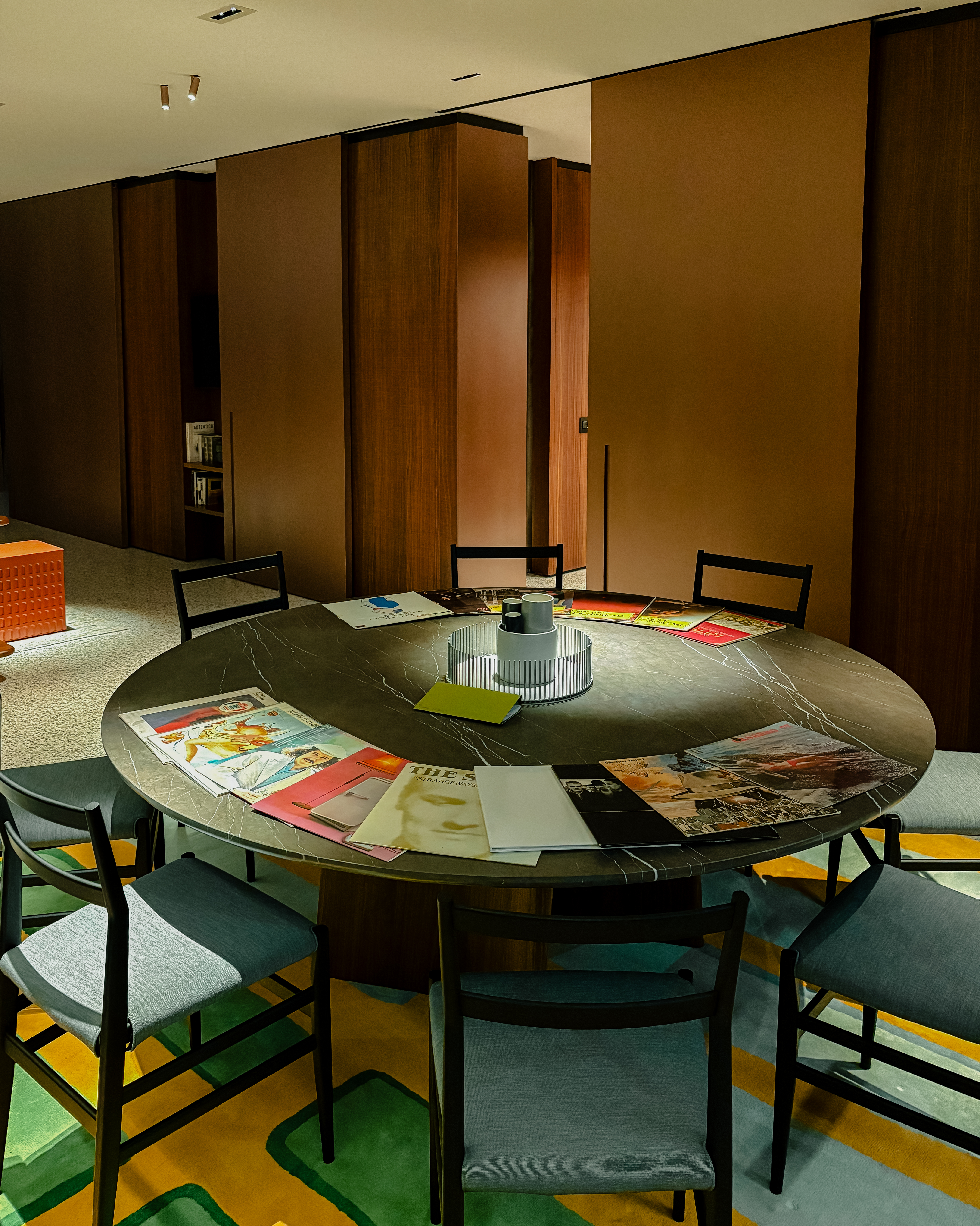 A mid-century modern-inspired hotel suite features earthy-tinted interiors, colorful design collectibles, and plenty of music equipment.