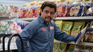 Richard Montanez looks at someone while stacking shelves in Flamin' Hot