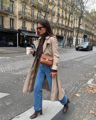 woman in trench coat, straight-leg jeans, and boots