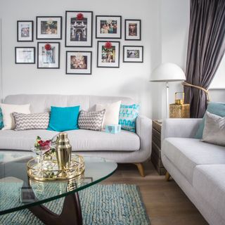 living room with photo frame on white wall and sofa set with cushions