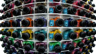 Ricoh Co. Pentax K-50 digital single lens reflex (DSLR) cameras sit on display at the CP+ Camera and Photo Imaging Show in this photograph taken with a fish-eye lens in Yokohama, Kanagawa Prefecture, Japan, on Thursday, Feb. 13, 2014