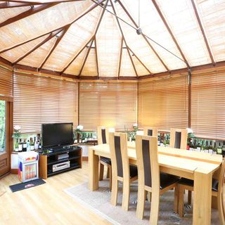 conservatory with tv and wooden table with chairs