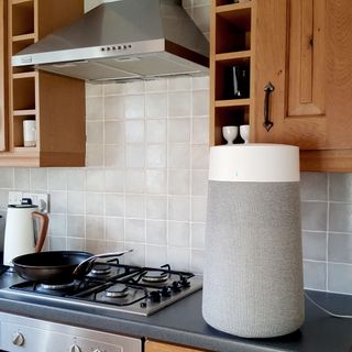 The Blueair Blue Max 3250i Air Purifier with grey fabric cover in a kitchen with wooden cupboards and a grey worktop