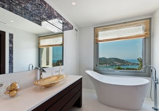 bathroom with bathtub and white wall and washbasin