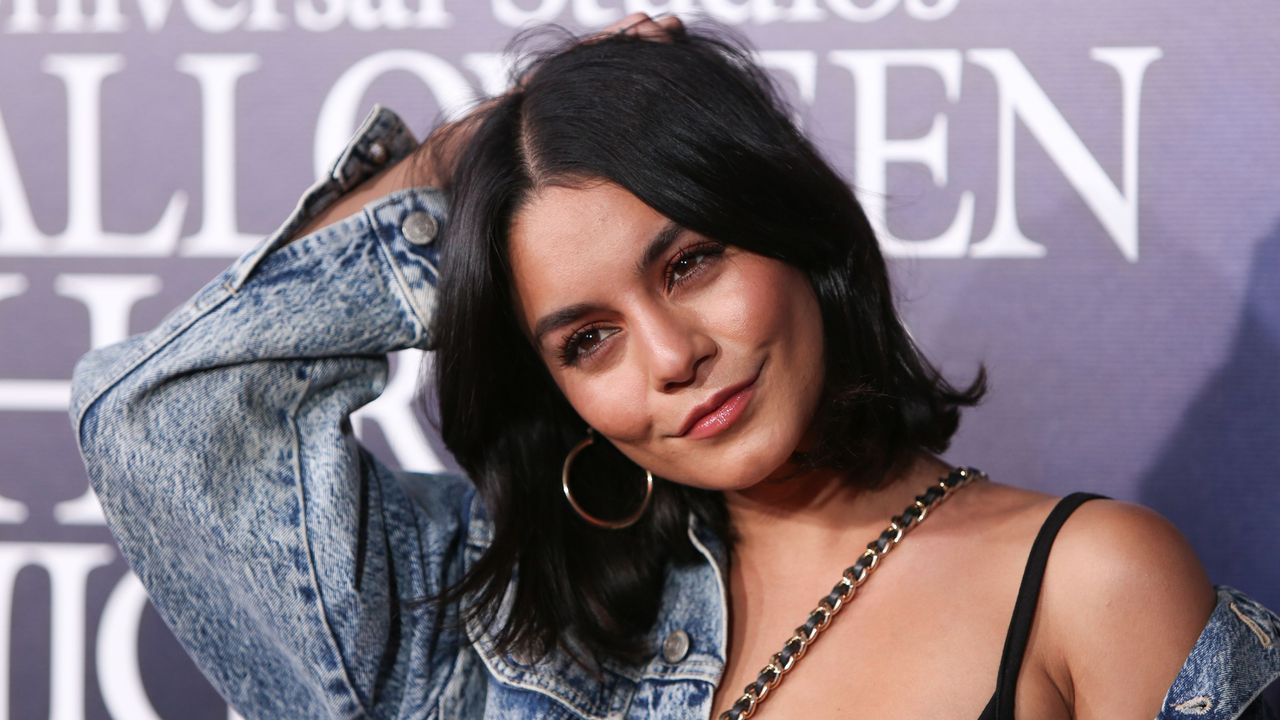 Vanessa Hudgens with a black bob, denim jacket, and gold chain