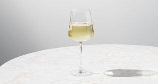 White wine in wine glass sitting on marble table