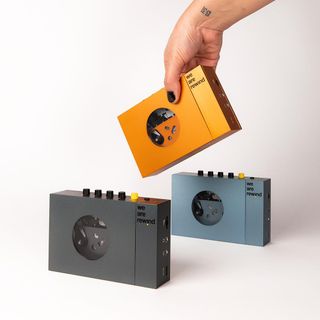 Hand picks up orange portable Cassette Player by We Are Rewind
