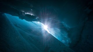 View of sun from deep glacial crevasse