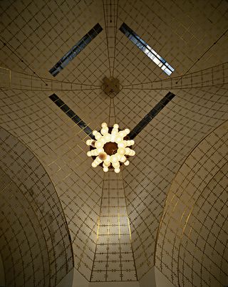Domed ceiling lined with pale tiles and surrounded in gold