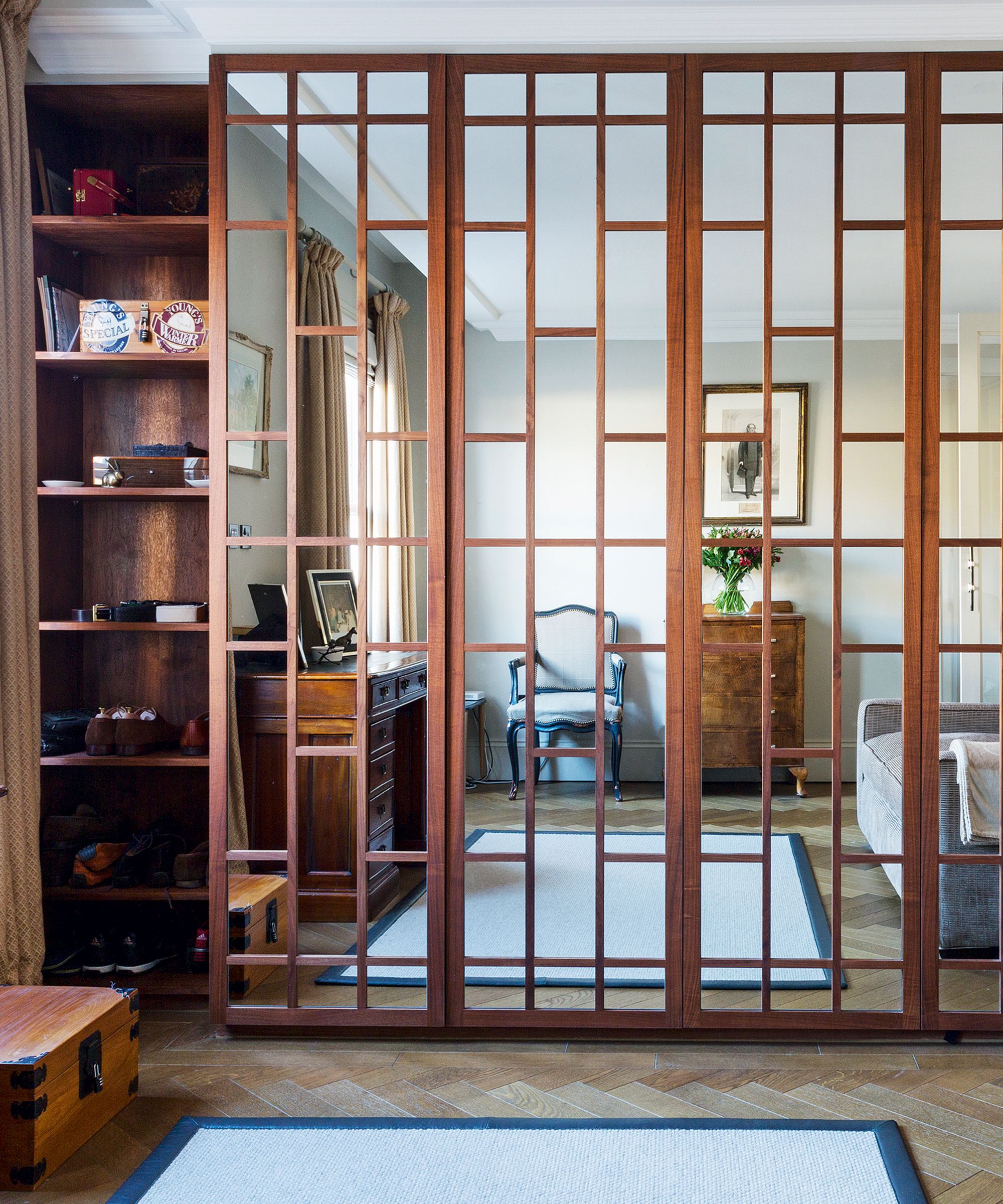 A living room mirror idea with a floor-to-ceiling mirrored cabinet with wooden framing