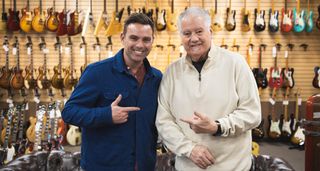 TNAG Global founder/CEO Ben Montague [left] and Norman Harris [right] point to each other as they are photographed on the shop floor at Norman's Rare Guitars.