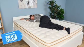 Tom's Guide mattress tester lying on her side on the Saatva Classic mattress in a blue-painted bedroom