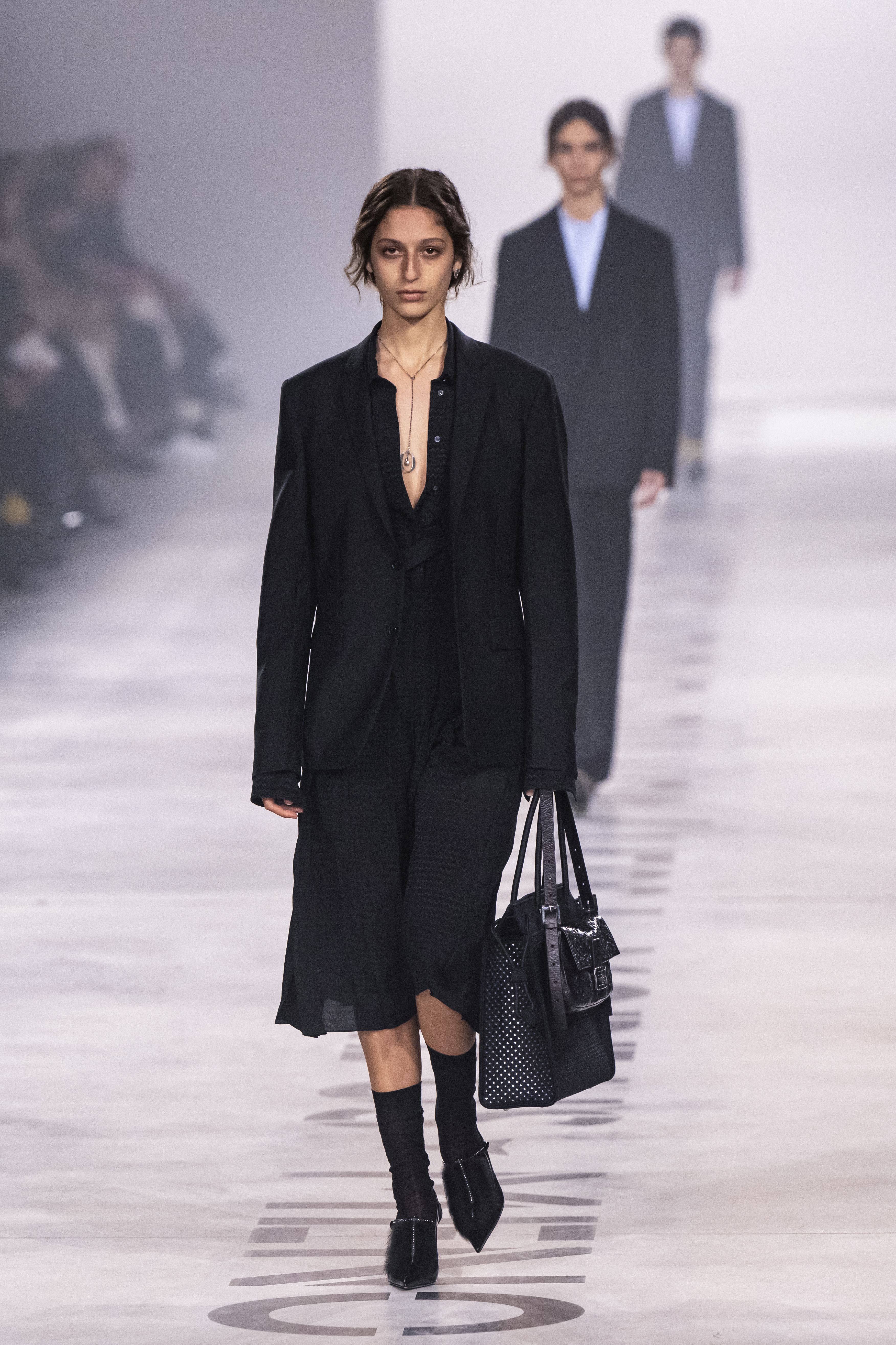 a model on the Fendi runway carrying a black bag