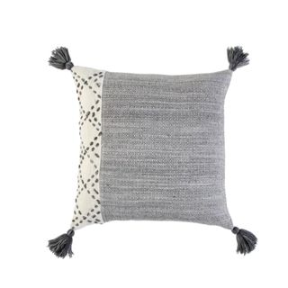 A gray outdoor pillow with tassels on the corners