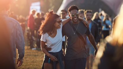 Stock photo of young happy couple laughing at outdoor music festival 